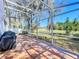Relaxing screened patio with brick floors, overlooking a serene pond view and mature landscaping at 2112 White Eagle St, Clermont, FL 34714