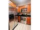Spacious kitchen featuring stainless steel appliances, warm wood cabinetry, and modern backsplash at 2624 Robert Trent Jones Dr # 633, Orlando, FL 32835