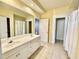Bright bathroom featuring double sinks, tile flooring, and white cabinets, with three doorways visible at 307 Running Wind Ln, Maitland, FL 32751