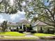 Charming single-story home featuring a manicured front lawn, mature trees, and a tile roof at 307 Running Wind Ln, Maitland, FL 32751