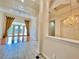 Spacious living area with tile flooring, French doors to the backyard, and elegant golden drapes at 307 Running Wind Ln, Maitland, FL 32751