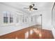Sunny bedroom with hardwood floors, large mirrored closet, and two shuttered windows at 33333 Somerset Dr, Leesburg, FL 34788