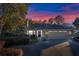 Charming single-story home featuring a well-manicured lawn and a spacious two-car garage at sunset at 33333 Somerset Dr, Leesburg, FL 34788