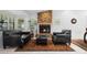 Elegant living room featuring a brick fireplace, large windows, and comfortable leather seating at 33333 Somerset Dr, Leesburg, FL 34788