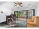 Cozy living room with slate tile flooring, bar area, and glass doors to the lanai at 33333 Somerset Dr, Leesburg, FL 34788