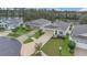 An aerial view shows well-maintained homes with lush landscaping in a quiet neighborhood near a pond at 4009 Swan Goose Ct, Okahumpka, FL 34762