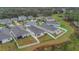 An aerial view of a suburban neighborhood shows homes with well-kept lawns and a community pond nearby at 4009 Swan Goose Ct, Okahumpka, FL 34762