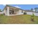Spacious backyard featuring a covered patio with a ceiling fan and outdoor dining set at 4009 Swan Goose Ct, Okahumpka, FL 34762