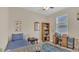 Comfortable bedroom with a blue accent rug, bed, desk, and bookshelf at 4009 Swan Goose Ct, Okahumpka, FL 34762