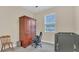 Neutral bedroom with a dark wood hutch, grey carpet, and large window letting in natural light at 4009 Swan Goose Ct, Okahumpka, FL 34762