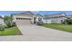 Beautiful single-Gathering home showcasing a driveway and tasteful landscaping at 4009 Swan Goose Ct, Okahumpka, FL 34762