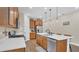 Well-lit kitchen with stainless appliances, wood cabinets, stone countertops, and a modern island with bar seating at 4009 Swan Goose Ct, Okahumpka, FL 34762