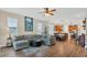 Bright open-concept living area with hardwood floors and a large sectional sofa at 4009 Swan Goose Ct, Okahumpka, FL 34762