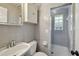 Retro tiled bathroom featuring a walk-in shower with glass block window, vanity, and medicine cabinet at 4249 Kendrick Rd, Orlando, FL 32804
