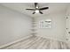 Well-lit bedroom with whitewashed wood-look floors, shelving, shutters, and a modern ceiling fan at 4249 Kendrick Rd, Orlando, FL 32804