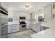 Modern kitchen with stainless steel appliances, white cabinets, white subway tile backsplash, and stylish flooring at 4249 Kendrick Rd, Orlando, FL 32804