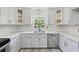 Modern white kitchen with stainless steel appliances, updated cabinetry, and ample counter space at 4249 Kendrick Rd, Orlando, FL 32804