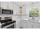 Updated kitchen featuring stainless steel appliances, white cabinetry, subway tile and modern fixtures at 4249 Kendrick Rd, Orlando, FL 32804
