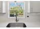 Bright kitchen with stainless steel sink, white quartz countertops, white cabinets, and natural light at 4249 Kendrick Rd, Orlando, FL 32804