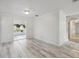 Living room with bright whitewashed wood-look floors and neutral walls, leading to outdoor living spaces at 4249 Kendrick Rd, Orlando, FL 32804