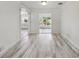 Spacious living room with wood-look floors, neutral walls, and doorways leading to a kitchen and screened lanai at 4249 Kendrick Rd, Orlando, FL 32804