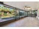 This is a view of the screened-in patio with tile flooring, ceiling fans and a great view of the lush backyard at 4249 Kendrick Rd, Orlando, FL 32804