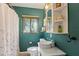 Bathroom featuring decorative green walls, bright lighting, patterned floors and shower at 430 S Virginia Ave, Sanford, FL 32771