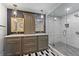 Modern bathroom featuring double vanities, elegant mirrors, a glass-enclosed shower, and designer tile floors at 430 S Virginia Ave, Sanford, FL 32771
