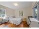 Bright bedroom featuring two windows, wood floors, and a white bed and furniture at 430 S Virginia Ave, Sanford, FL 32771