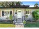Inviting covered porch with a white front door, metal railings, and decorative plants at 430 S Virginia Ave, Sanford, FL 32771