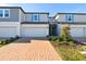 Charming townhome featuring a brick driveway, one-car garage and neat landscaping at 4332 Ranch House Rd, St Cloud, FL 34772