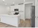 Bright white kitchen with stainless appliances, large island with sink, and hardwood style floors at 4332 Ranch House Rd, St Cloud, FL 34772