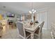 Dining area with modern furniture, chandelier and tiled floors adjoining the living room with large windows at 4475 Casablanca Ave, Kissimmee, FL 34746