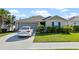 Well maintained home with neat landscaping and an attached two-car garage with a car in the driveway at 4475 Casablanca Ave, Kissimmee, FL 34746