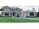 Stately two-story home featuring a metal roof, front-facing three-car garage, and neatly manicured landscaping at 4654 Thornlea Rd, Orlando, FL 32817