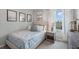 Cozy bedroom featuring beach themed decor, side table with lamp, and large window allowing plenty of natural light at 487 Taylor Groves Dr, Lake Wales, FL 33898