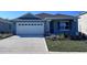 Charming blue one-story home with well-manicured lawn and a two car garage at 487 Taylor Groves Dr, Lake Wales, FL 33898