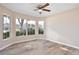 Bedroom with wood-look floors, a ceiling fan, and large windows with backyard view at 604 Coral Trace Blvd, Edgewater, FL 32132
