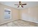 Bedroom with wood-look floors, a ceiling fan, and window at 604 Coral Trace Blvd, Edgewater, FL 32132