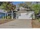 Well-kept home exterior with a spacious two-car garage and mature landscaping at 604 Coral Trace Blvd, Edgewater, FL 32132