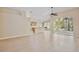 Bright open-plan living area with tile floors and recessed lighting, leading to the kitchen at 604 Coral Trace Blvd, Edgewater, FL 32132