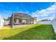 Manicured backyard with green grass, white fence, and screened-in porch at 706 Hyperion Dr, Debary, FL 32713