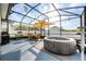 Screened-in patio with a spa, seating, grill and lighting, great for relaxing and entertaining at 706 Hyperion Dr, Debary, FL 32713