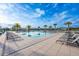 Community pool surrounded by lounge chairs and palm trees on a sunny day at 706 Hyperion Dr, Debary, FL 32713