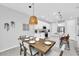 Dining area with a wooden table, bench seating, modern lighting, and view of kitchen at 730 Longboat Dr, Davenport, FL 33896