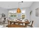 Dining area with a wooden table, bench seating, modern lighting, and view of sofa through window at 730 Longboat Dr, Davenport, FL 33896
