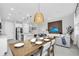 Dining area with a wooden table, bench seating, modern lighting, and view of living area at 730 Longboat Dr, Davenport, FL 33896