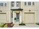 Inviting townhome featuring a stylish blue front door, lush landscaping, and an attached single car garage at 730 Longboat Dr, Davenport, FL 33896