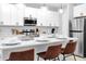 Well-lit kitchen featuring a quartz countertop island, stainless steel appliances, and bar stool seating at 730 Longboat Dr, Davenport, FL 33896