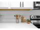 Stylish kitchen counter featuring decorative wooden houses, plant, and utensils against a modern backsplash at 730 Longboat Dr, Davenport, FL 33896